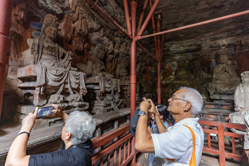 Des visiteurs visitent un site pittoresque des sculptures rupestres de Dazu