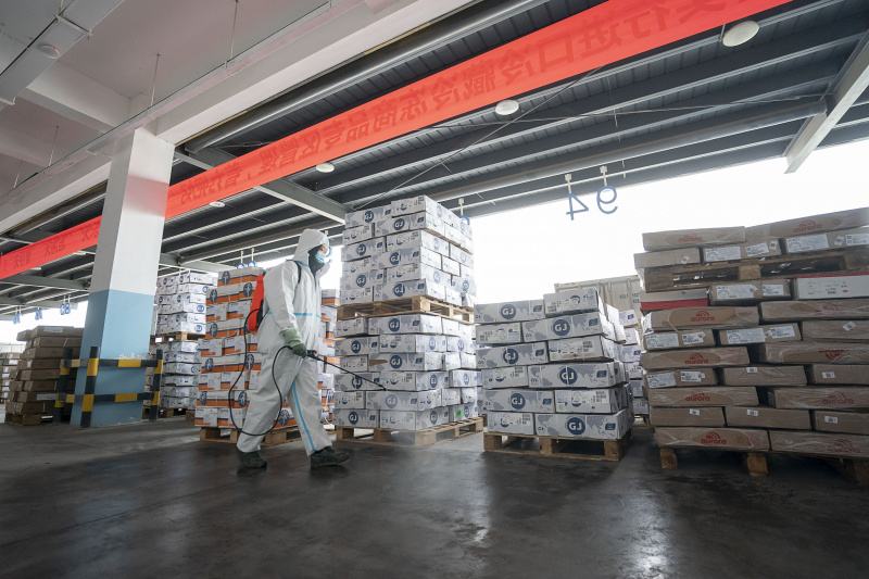 Un employé pulvérise du désinfectant dans un centre régional de la chaîne du froid à Wuhan