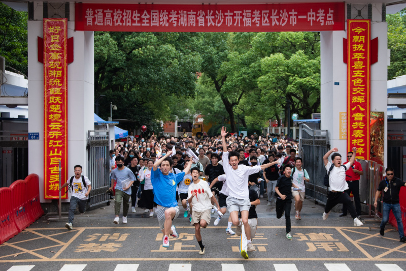 Des candidats sortent en courant d'un site d'examen du concours national d'entrée à l'université à Changsha