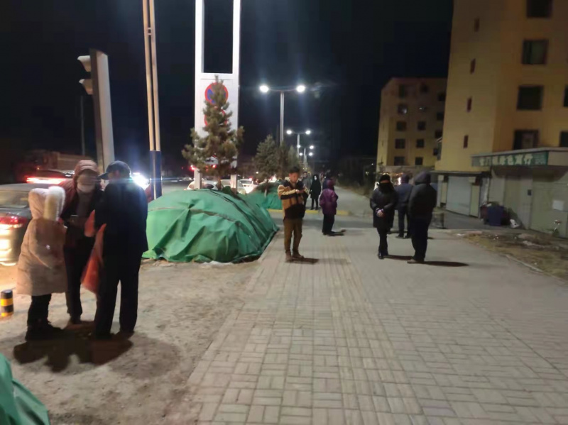 Des gens à l'extérieur de bâtiments pour échapper au séisme dans le district de Menyuan