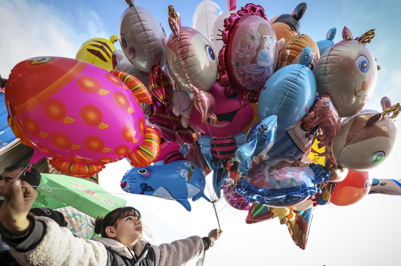 Une commerçante vend des ballons dans un bazar hebdomadaire du bourg de Tokkuzak