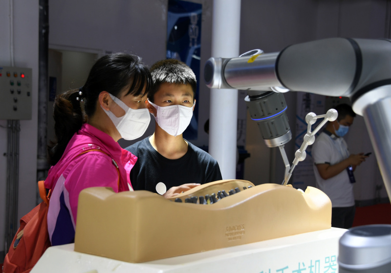 Des visiteurs observent un robot de chirurgie orthopédique lors de la Conférence mondiale de la robotique 2021 à Beijing