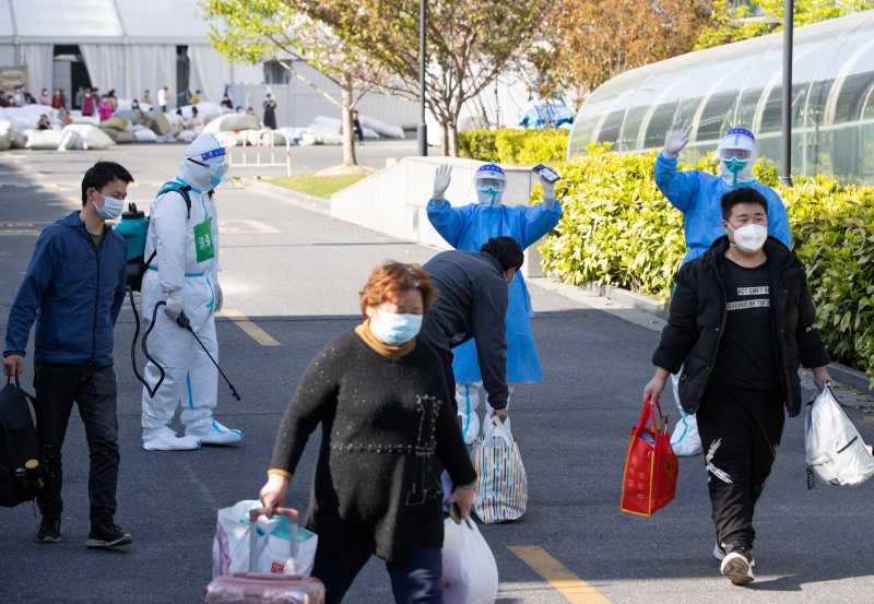 Des patients rétablis de la COVID-19 quittent un hôpital temporaire installé au Centre des expositions et des congrès pour l'approvisionnement international à Shanghai