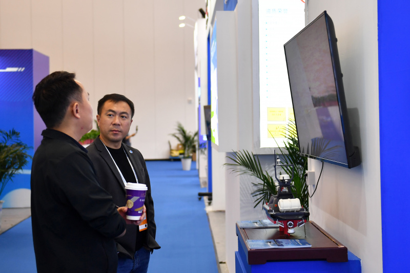 Des visiteurs découvrent une exposition au Centre de conférence international de Changsha lors de la deuxième conférence du Forum sur le développement économique et la sécurité du monde dans le cadre du Forum de Boao pour l'Asie (FBA) à Changsha