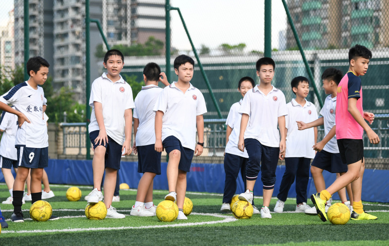 Des enfants participent à une séance d'entraînement sur un terrain de sport aménagé sur le toit d'un bâtiment de l'école secondaire No