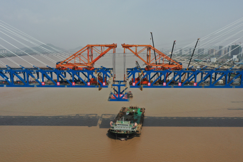 Le dernier élément en acier du tablier est hissé sur le chantier de construction du grand pont de Jiaojiang