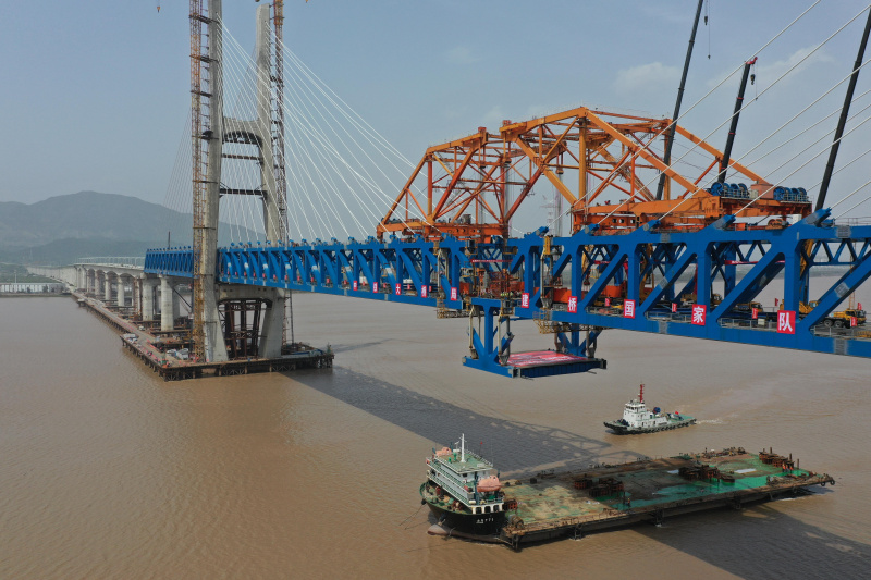 Le dernier élément en acier du tablier est hissé sur le chantier de construction du grand pont de Jiaojiang