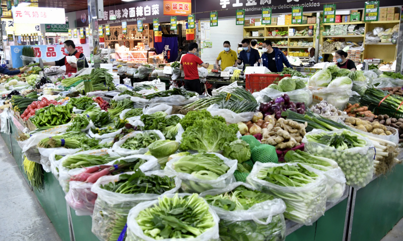 Des clients achètent des légumes dans un marché de l'arrondissement de Chaoyang à Beijing