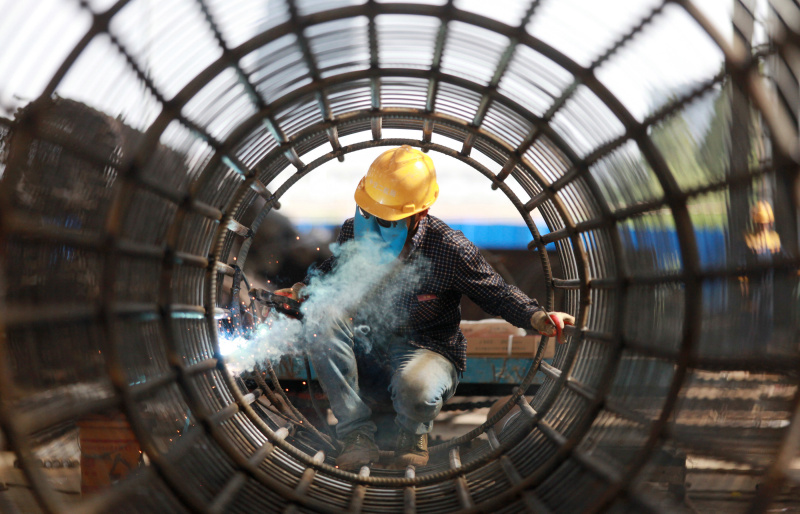 Un constructeur brave la chaleur travaillant sur un chantier de construction dans le bourg de Wantou