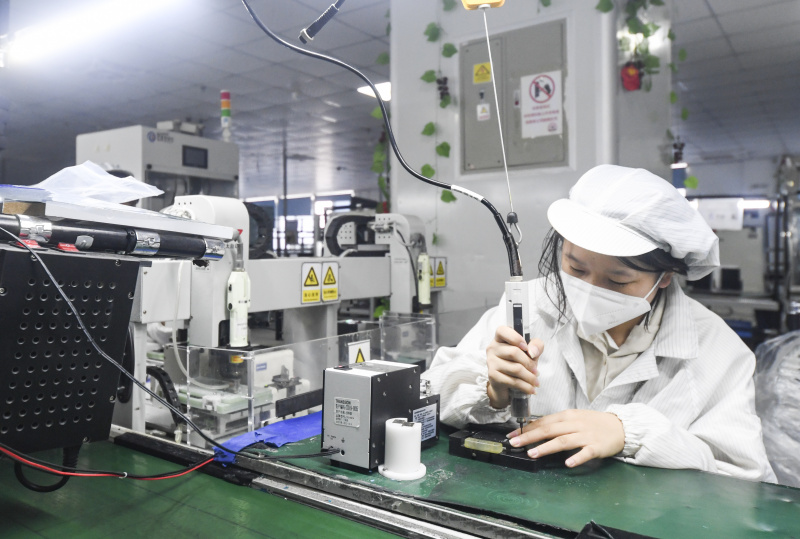 Une employée travaille dans l'atelier de production et de contrôle de la qualité des smartphones de Chongqing Transsion Technology Co
