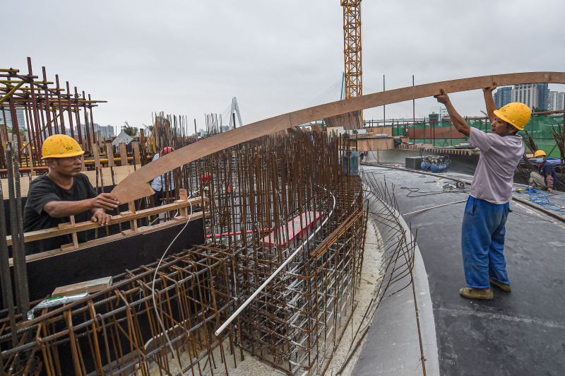 Des ouvriers travaillent dans le site de construction de la Bibliothèque Wormwhole dans la baie de Haikou