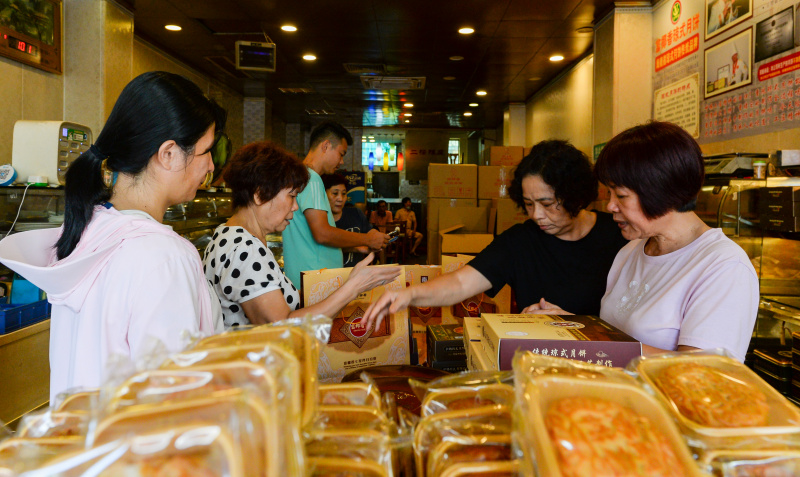 Des consommateurs choisissent des gâteaux de lune dans un magasin de gâteaux de lune à la mode de Hainan