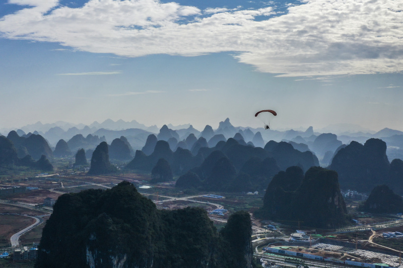 Un touriste fait du parapente en duo avec un moniteur à Guilin