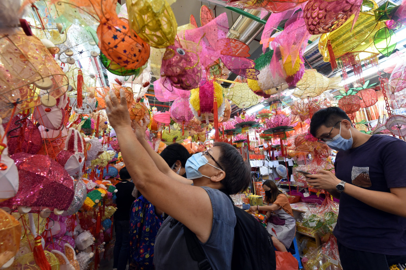 Des habitants choisissent des lanternes pour célébrer la prochaine fête de la mi-automne dans un marché de rue à Hong Kong