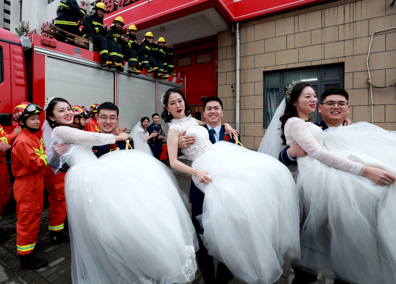 Des pompiers et leurs épouses posent lors de leur cérémonie de mariage de groupe à Shanghai