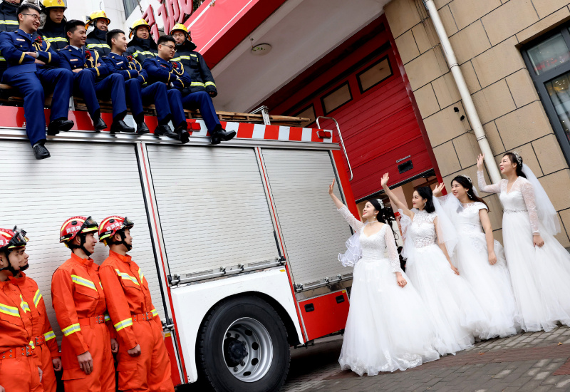 Des pompiers et leurs épouses posent lors de leur cérémonie de mariage de groupe à Shanghai