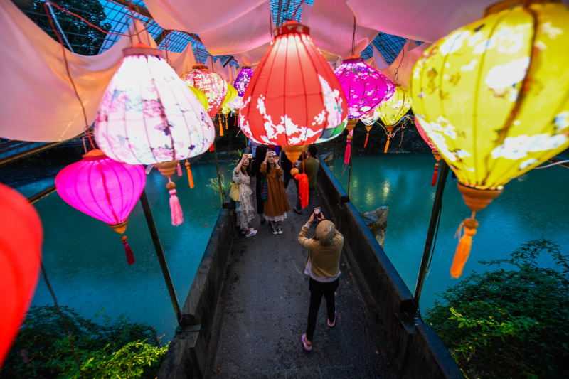 Des touristes observent des lanternes lors d'une foire du temple dans la vieille ville de Longmen à Hangzhou