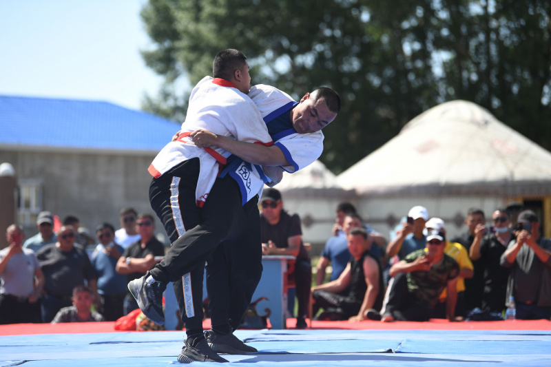 Des bergers participent à un jeu de lutte lors d'un festival du tourisme dans le district de Fuhai