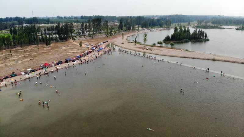 Photo aérienne de visiteurs dans une zone écologique de la phase III du projet de restauration de la rivière Hutuo