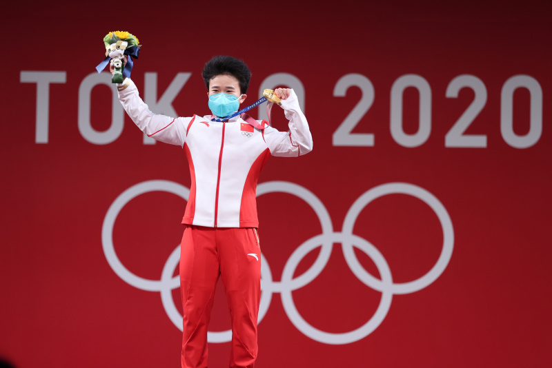 La Chinoise Hou Zhihui pose pour une photo lors de la cérémonie de remise des médailles après la finale de l'épreuve d'haltérophilie 49kg dames des Jeux olympiques de Tokyo