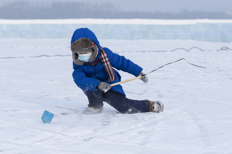 Un enfant s'amuse sur le fleuve Songhua gelé dans un parc d'attractions de neige et de glace à Harbin
