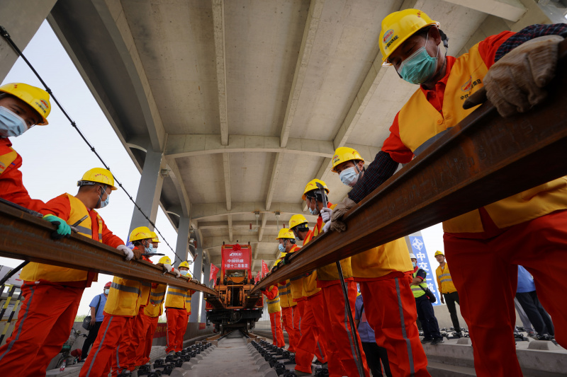 Des ouvriers posent des rails pour la section au Hebei du chemin de fer interurbain Beijing-Xiongan