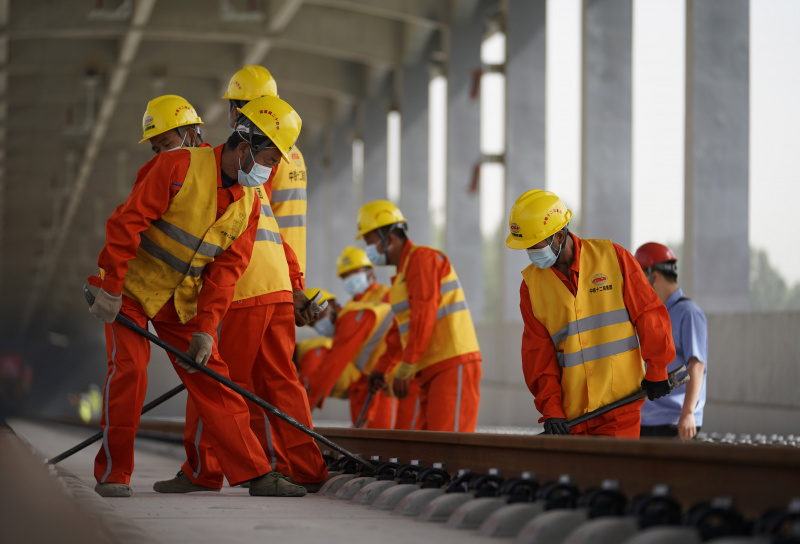 Des ouvriers posent des rails pour la section au Hebei du chemin de fer interurbain Beijing-Xiongan