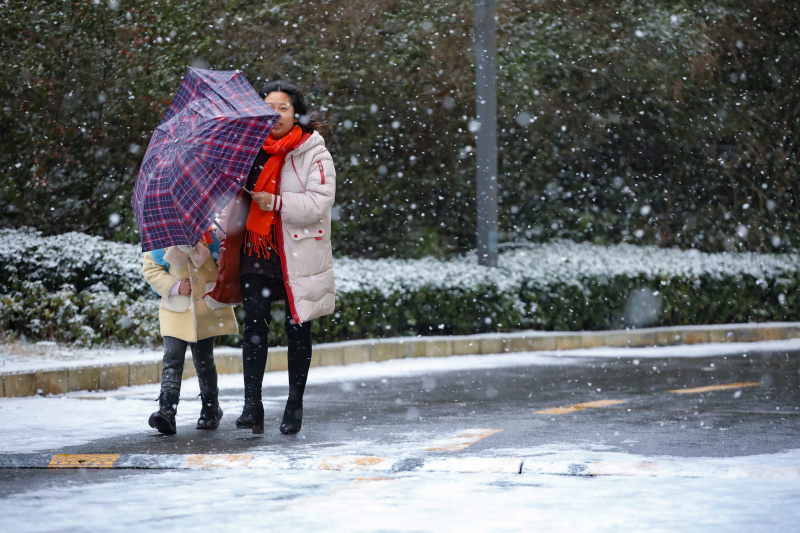 Des gens marchent sous la neige à Guiyang