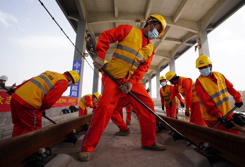 Des ouvriers posent des rails pour la section au Hebei du chemin de fer interurbain Beijing-Xiongan