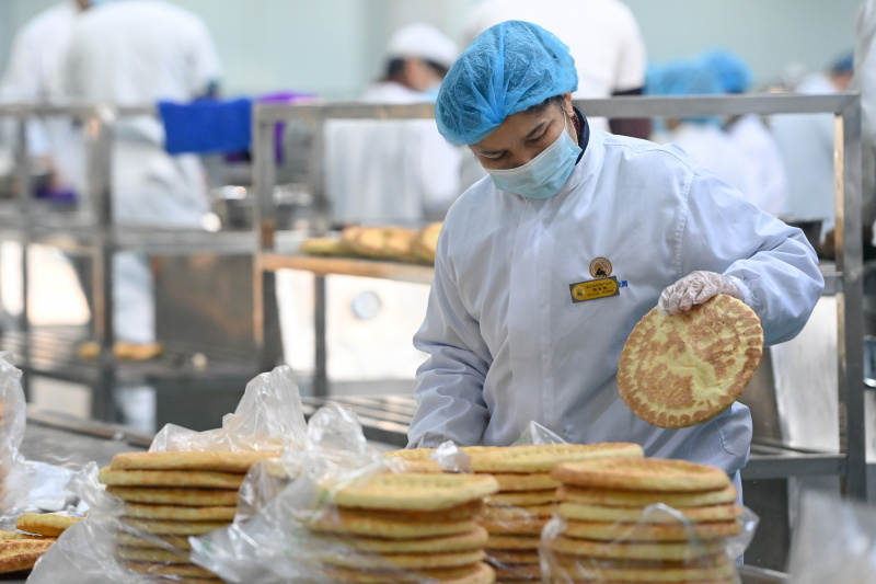 Un ouvrier trie des pains locaux plats (Nang) nouvellement préparés dans un atelier d'un parc industriel à Horgos
