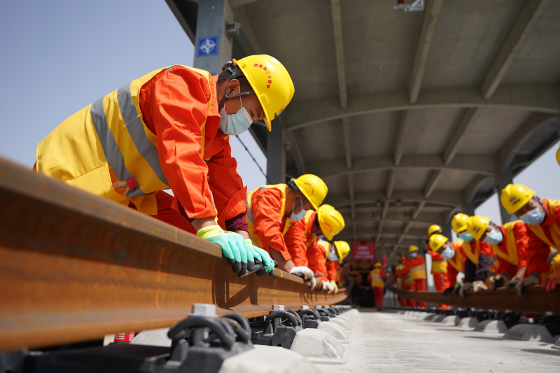 Des ouvriers posent des rails pour la section au Hebei du chemin de fer interurbain Beijing-Xiongan