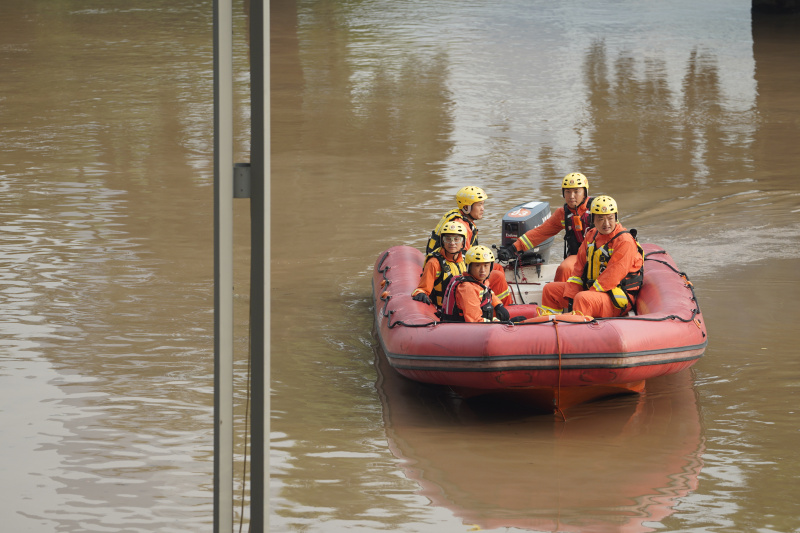 Des secouristes patrouillent dans une zone inondée de la rue Nanbin