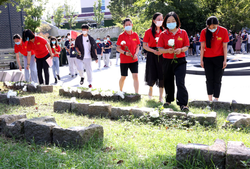 Des gens présentent des gerbes de fleurs lors d'un événement commémoratif organisé à l'occasion de la Journée des martyrs de Chine