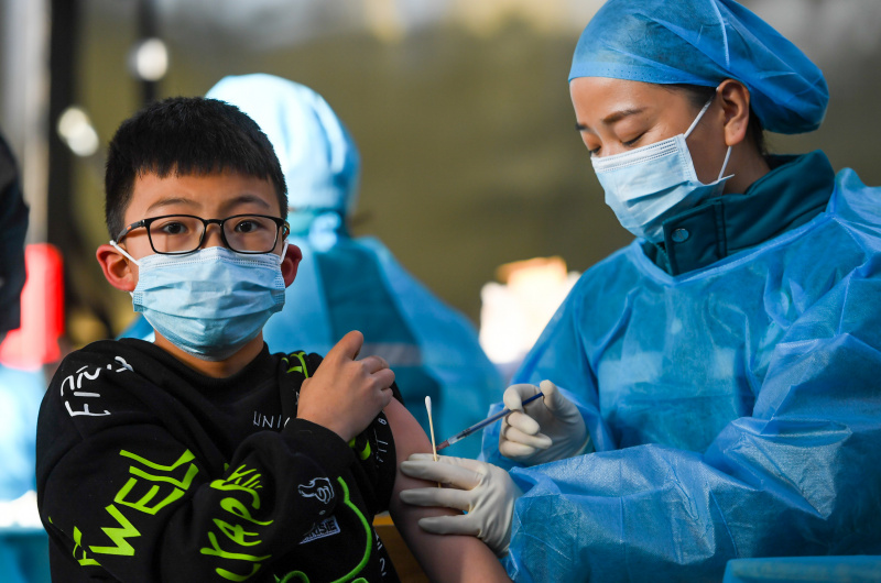 Un garçon reçoit une dose de vaccin de COVID-19 dans une école à Hohhot
