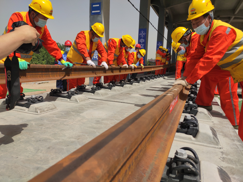 Des ouvriers posent des rails pour la section au Hebei du chemin de fer interurbain Beijing-Xiongan