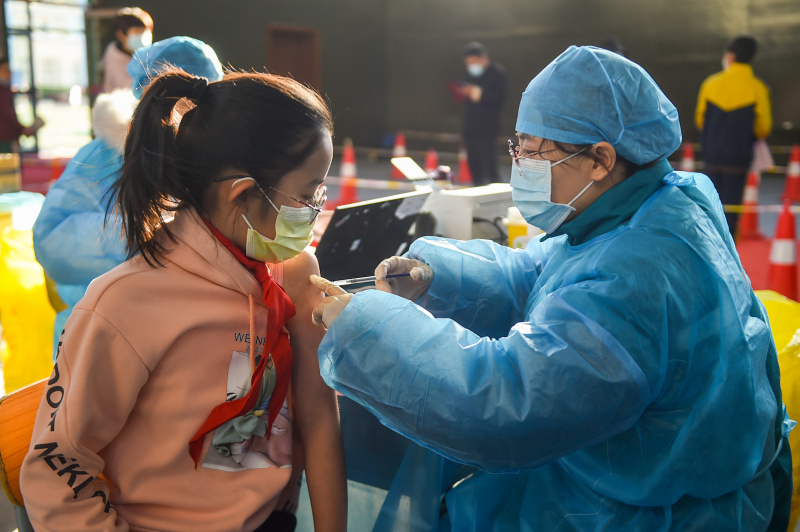 Une fille reçoit une dose de vaccin de COVID-19 dans une école à Hohhot