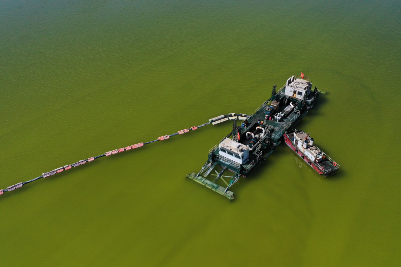 Photo aérienne prise le 1er avril 2022 montrant un bateau collectant du sel brut dans un lac salé de la province chinoise du Qinghai (nord-ouest)