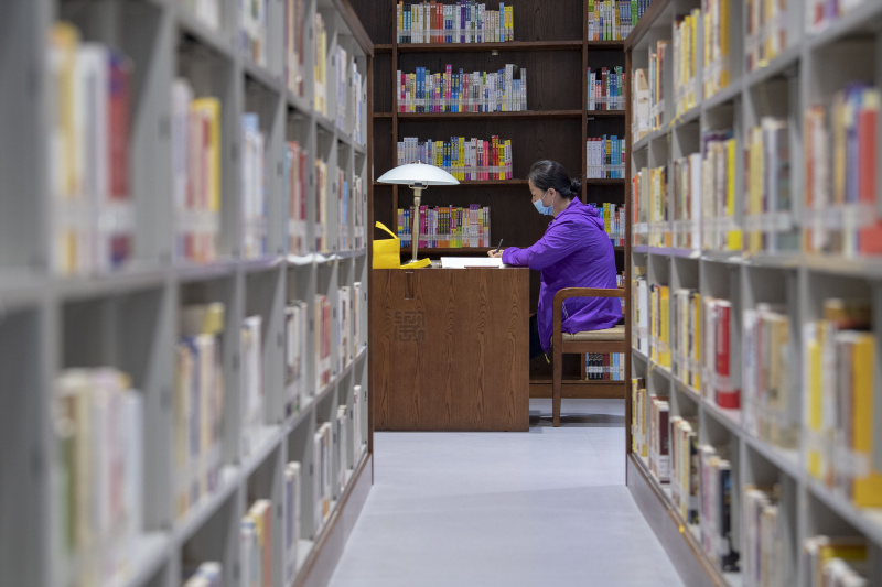 Une femme lit dans une bibliothèque pendant les vacances à l'occasion de la fête des bateaux-dragons