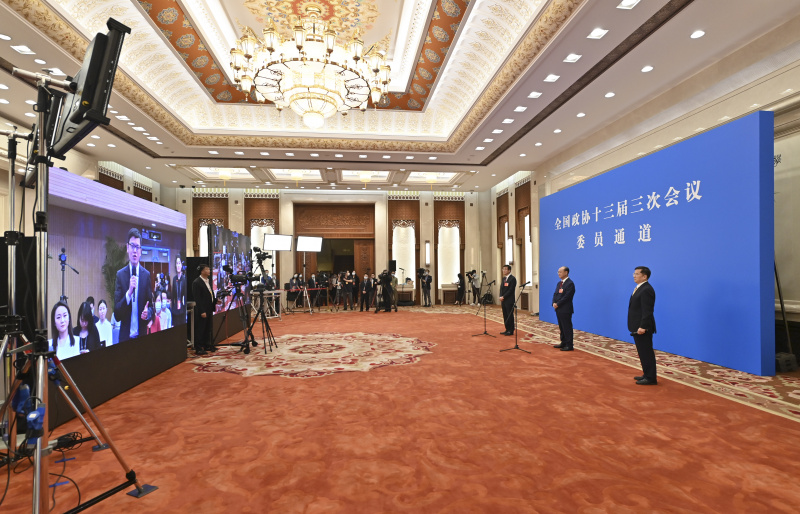 Des membres du 13e Comité national de la Conférence consultative politique du peuple chinois (CCPPC) sont interviewés par liaison vidéo avant l'ouverture de la troisième session du 13e Comité national de la CCPPC au Grand Palais du Peuple à Beijing