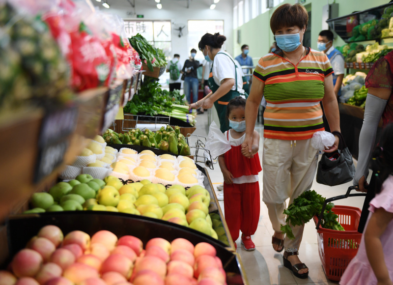 Des consommateurs achètent des légumes dans une épicerie installée récemment près du marché de gros de Xinfadi à Beijing