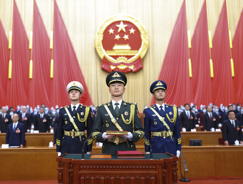 La garde d'honneur de l'Armée populaire de libération (APL) de la Chine porte un exemplaire de la Constitution du pays lors de la cérémonie d'allégeance à la Constitution chinoise pour les dirigeants nouvellement élus du pays qui se déroule au Grand Palais du Peuple