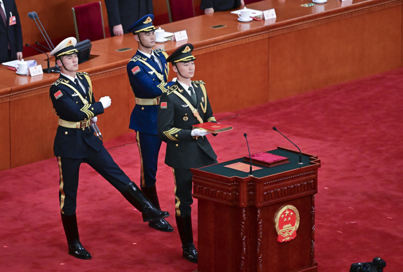 La garde d'honneur de l'Armée populaire de libération (APL) de la Chine porte un exemplaire de la Constitution du pays lors de la cérémonie d'allégeance à la Constitution chinoise pour les dirigeants nouvellement élus du pays qui se déroule au Grand Palais du Peuple