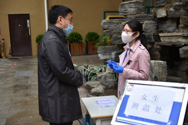 Des employés font la répétition du retour des élèves dans une salle de classe dans le département de collège de l'école secondaire Chenjinglun à Beijing