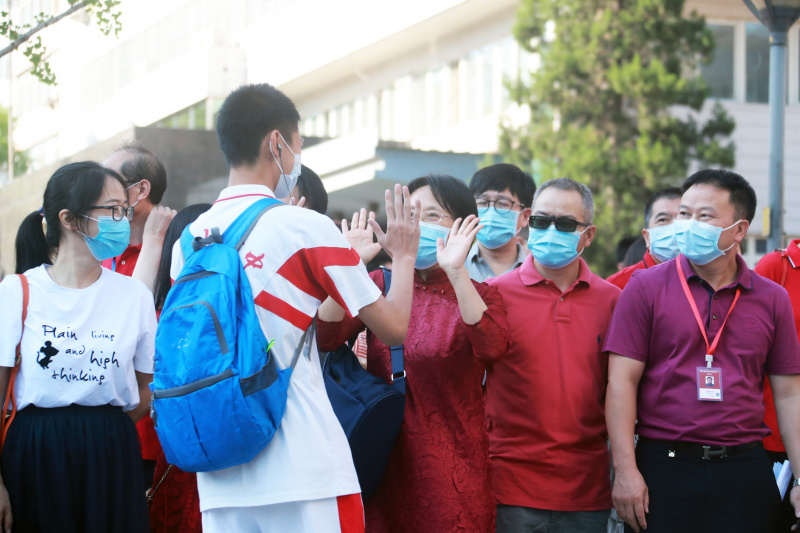 Les enseignants encouragent les candidats à l'extérieur d'un site d'examen à Beijing