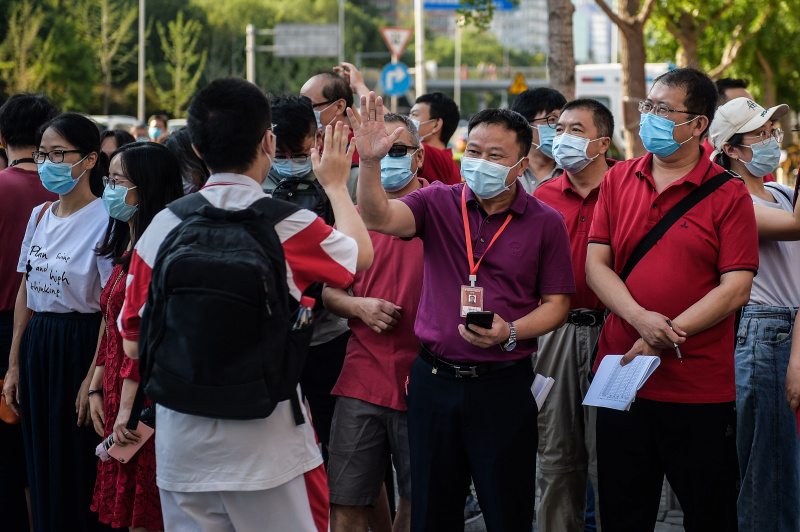 Un enseignant encourage un candidat à l'extérieur d'un site d'examen à Beijing
