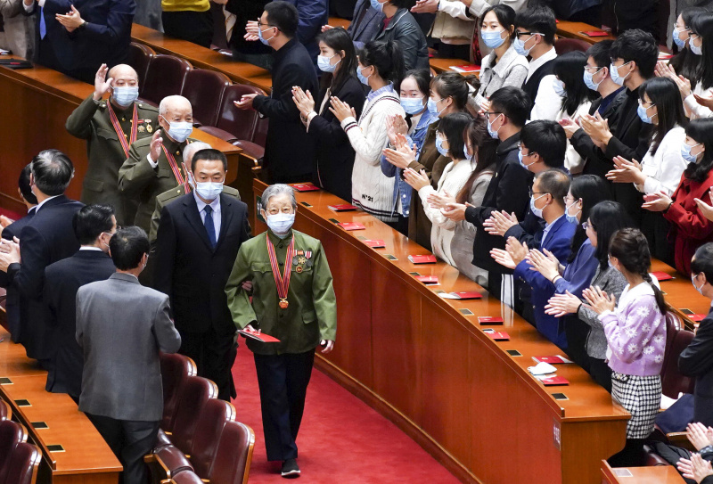 Des vétérans des Volontaires du peuple chinois (VPC) entrent dans la salle de la réunion marquant le 70e anniversaire de l'entrée des VPC en République populaire démocratique de Corée (RPDC) pour combattre dans la Guerre de résistance à l'agression américaine et d'aide à la RPDC