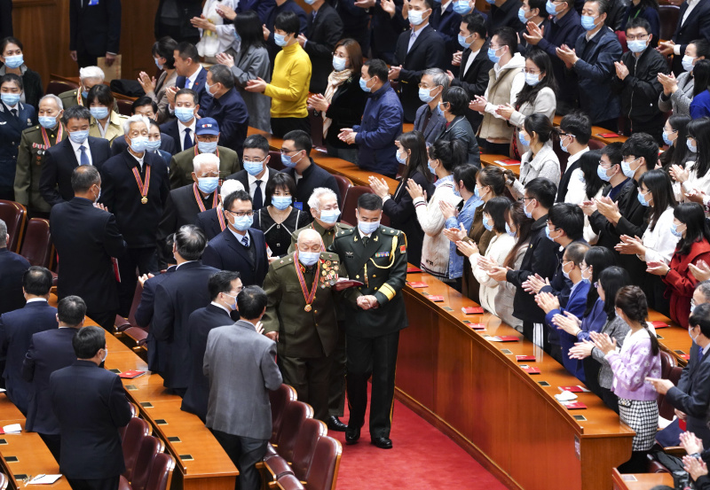 Des vétérans des Volontaires du peuple chinois (VPC) entrent dans la salle de la réunion marquant le 70e anniversaire de l'entrée des VPC en République populaire démocratique de Corée (RPDC) pour combattre dans la Guerre de résistance à l'agression américaine et d'aide à la RPDC