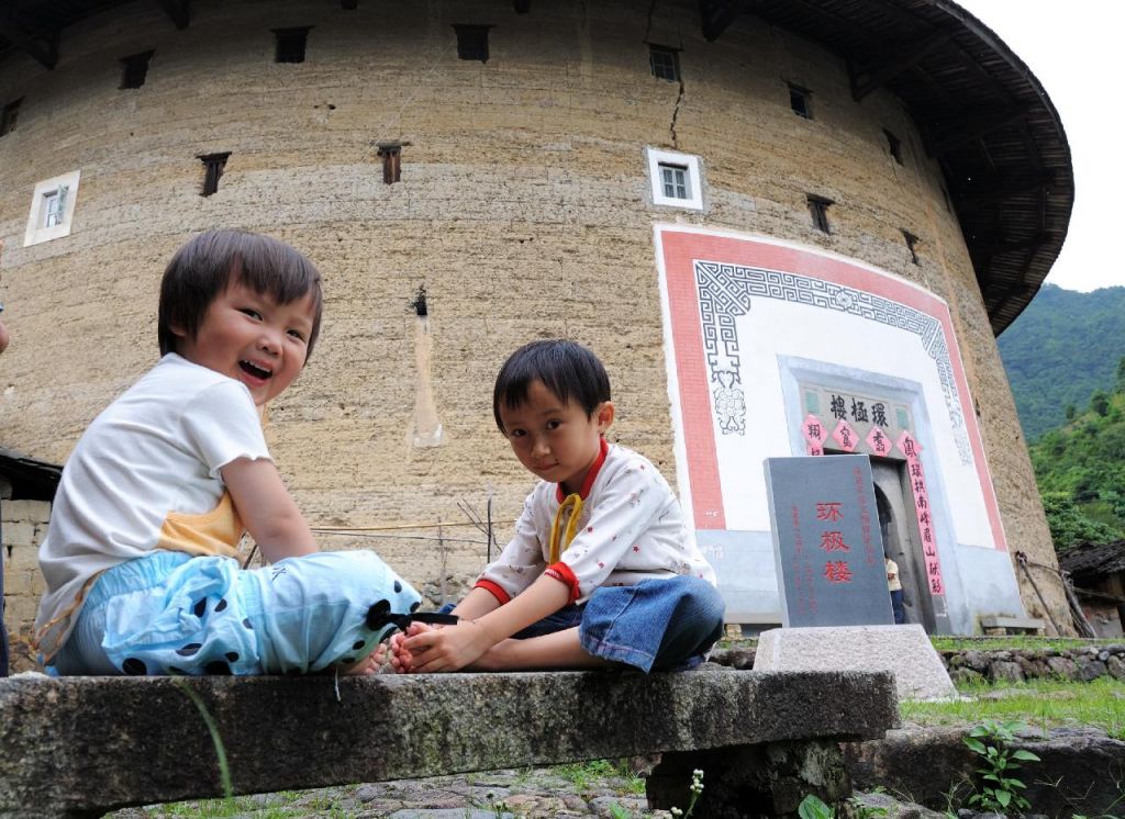 Enfants jouant devant des Tulou