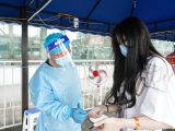 Un employé vérifie les informations d'identité et le code sanitaire d'une passagère à la gare de Nanjing
