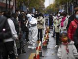 Un travailleur médical aide un habitant à faire enregistrer ses informations pour le test d'acide nucléique dans un site d'échantillonnage à Yinchuan